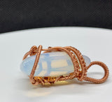 This Opalite Moon Pendant wrapped in Handwoven Copper is a beautifully crafted pendant that marries the mysticism of the moon with the earthy warmth of copper. Its celestial symbolism, glowing Opalite stone, and intricate copper weaving make it a unique and enchanting accessory, perfect for anyone who appreciates handmade, nature-inspired jewelry.