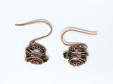 Dainty handwoven copper earrings with metallic crystals hang from hand made copper ear wires.
