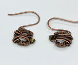 Dainty handwoven copper earrings with metallic crystals hang from hand made copper ear wires.