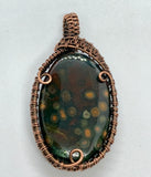 Colorful orbs sprout out in this dark green and red Jasper Pendant in Copper. 