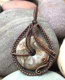 Intricately Woven Copper Crazy Lace Agate Donut Pendant.