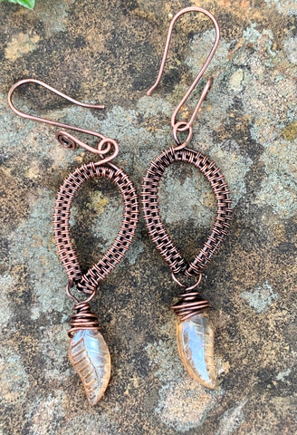 Handwoven wire wrapped copper earrings with yellow glass leaf dangles.
