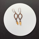Handwoven wire wrapped copper earrings with yellow glass leaf dangles.