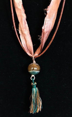 This Necklace features a 15mm striped agate, copper, Hand Dyed Recycled Sari Silk Ribbon, Leather and Nylon Tassel  Cords are adjustable up to 36"