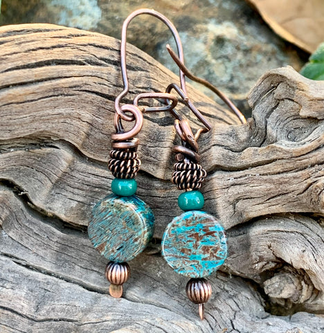 These earrings feature hammered copper, copper beads, calsilica bead, glass bead, and coiled copper on a handmade copper kidney ear wire.