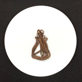 This Pendant features asymmetrical layers of hand wrapped, woven and coiled copper wire with a quartz bead accent.