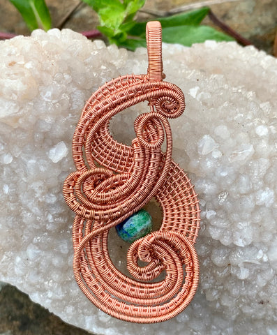 Layers of handwoven copper and copper coils surround a Lapis Chrysocolla Bead, creating a stunning intricate pendant.