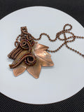 Hand cut, formed, and textured solid Copper Leaf Pendant, intricately wrapped with hand woven copper and glass beads.