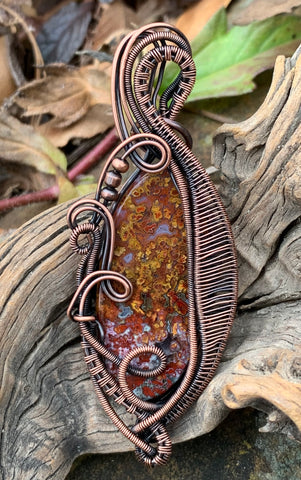 Colorful Red and Yellow Agate Pendant in layers of wire wrapped, curled and coiled copper.