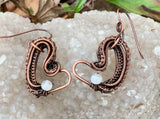 These earrings have layers of wire wrapped copper that form an asymetrical heart with a Rainbow Moonstone accent.