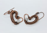 These earrings have layers of wire wrapped copper that form an asymetrical heart with a Rainbow Moonstone accent.