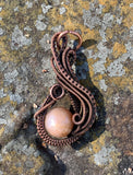 This Pendant has hand woven and coiled copper surround this shimmering Sunstone.