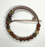Multi-colored Red Creek Jasper surrounds this handmade wire wrapped Copper Pin. 