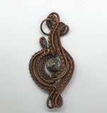 Wire wrapped Copper Pendant with handwoven and coiled copper layers with a Rain Forest Jasper Center.
