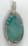A beautiful Quartz pendant with silicated Chrysocolla inclusions and Turquoise accent beads in wire wrapped Sterling (.925) and Fine (.999) Silver.