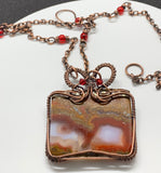 Polished Moroccan Seam Agate Slice Necklace wrapped in handwoven copper with Swarovski crystal accents and a copper chain with glass beads. 