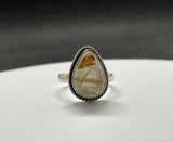 This stunning ring features a captivating Golden Rutilated Quartz gemstone, set in high-quality (.925) Sterling Silver. The golden threads within the quartz create a radiant, eye-catching effect, making this ring a timeless and elegant addition to any jewelry collection. Perfect for those who appreciate the natural beauty of gemstones and fine craftsmanship.