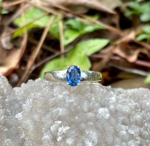 This exquisite ring showcases a faceted Blue Kyanite gemstone, known for its captivating deep blue hues and natural shimmer. Set in a sleek Sterling Silver band, the design highlights the stone's brilliance while offering a timeless elegance. Perfect as a statement piece or for everyday wear, this ring is a must-have for any jewelry enthusiast.