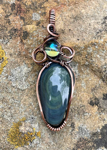 Swirling Velvet Obsidian Pendant made with a grooved cabochon, square Copper wire and Electroplated Quartz accent bead. 