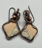 These Delightful Peach and Gray Maligano Jasper Earrings are a unique and striking combination of natural beauty and artisan craftsmanship. Featuring beautiful peach and gray Maligano Jasper stones, these earrings are wrapped in copper wire for an earthy yet elegant look. Paired with hypoallergenic niobium ear wires, these earrings are both stylish and comfortable, perfect for those with sensitive skin.