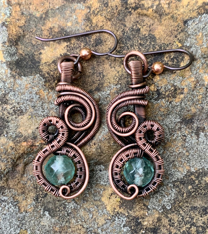 Handwoven Copper and Coils Swirl around light blue/green Faceted Fluroite in these Hypoallergenic Earrings.