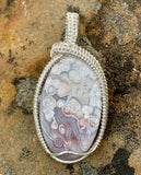 Orbicular Agate Pendant with Swirls of Purple and Pink with White Orbs in Wire Wrapped Sterling (.925) and Fine (.999) Silver. 