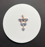 This Copper Pendant featuring 6 Blue Dumortierite Cabochons and 3 Faceted Rainbow Moonstones is a striking and intricate piece of jewelry. The pendant showcases a sophisticated blend of blue dumortierite and rainbow moonstone, all elegantly set in copper. This pendant embodies a harmonious combination of deep, rich colors and vibrant, iridescent highlights.