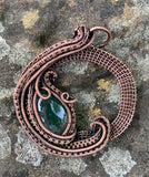 Round hand woven copper pendant with multiple layers and a Moss Agate Cabochon.