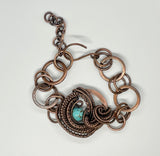 Multiple layers of wire wrapped copper surround turquoise in this adjustable length bracelet. 