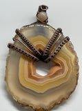 Beautiful One of a Kind Polished Agate Slice Pendant, with hues of peach and yellow, in wire wrapped Copper with a Sunstone Accent. 