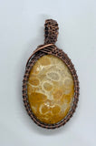 This Fossil Coral Pendant has beautiful sunburst patterns and is wrapped in hand woven copper.