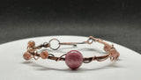 Rhodonite and Rhodochrosite Bracelet in Copper. With large Rhodonite in the center and smaller Rhodochrosites around the bracelet.