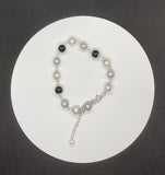 Versatile white, gray and black in this sterling silver bracelet features 8mm onyx beads and 7mm white and dyed gray freshwater cultured pearls. 