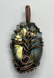 Immerse yourself in the mystical allure of the Labradorite Tree of Life Pendant. This captivating piece features a striking combination of dark, stormy Labradorite and vibrant Amazonite stars, all elegantly wrapped in copper. It’s a perfect representation of the enchanting beauty of a dark, stormy night.